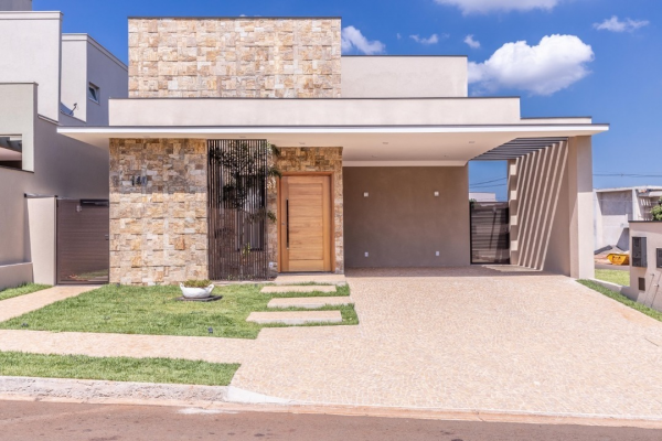 Fachada de casa térrea contemporânea em tons de cinza e com pedras